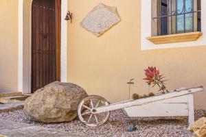 a wheelbarrow with flowers and a rock next to a building at Haus mit Pool auf Mallorca in Manacor