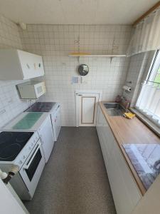 a small kitchen with white appliances and a window at Ferienwohnung-zum-Kueppchen in Münstermaifeld