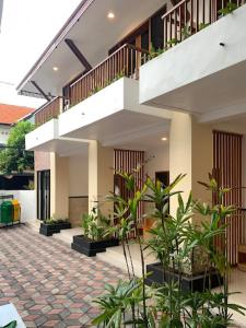 a house with a staircase and a courtyard with plants at LH - Norm House in Kuta