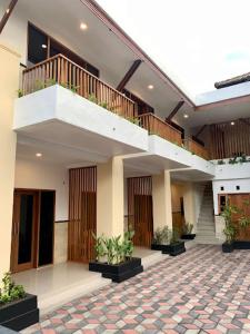 un edificio con una escalera y un patio con plantas en LH - Norm House, en Kuta
