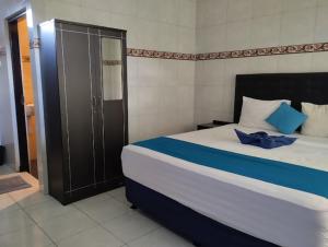 a bedroom with a large bed with blue pillows at LH - Norm House in Kuta