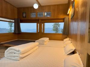Wanderlust Mukteshwar في مكتزور: غرفة نوم بسريرين بقارب