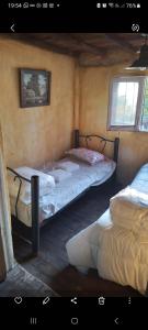 two twin beds in a room with two windows at HOSTEL CHACRAS in Ciudad Lujan de Cuyo