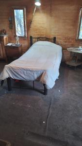1 dormitorio con 1 cama con manta blanca en HOSTEL CHACRAS en Luján de Cuyo