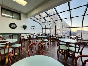 Dakota Inn في مينوت: مطعم بطاولات وكراسي ونوافذ