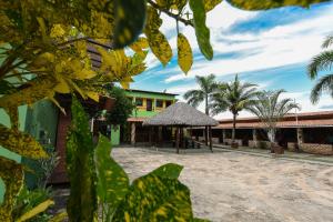 a building with a thatch roof and palm trees at Lençóis Maranhenses - 2 Hóspedes + Café da manhã in Barreirinhas