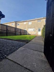 a sidewalk in front of a building with a fence at 2 Bed House Central Between Glasgow & Edinburgh in Kirk of Shotts