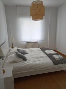 a bedroom with a white bed with pillows on it at Céntrico apartamento reformado de dos habitaciones in Logroño