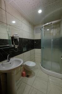 een badkamer met douche, wastafel en toilet bij Venüs Hotel in Antalya