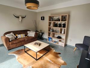 ein Wohnzimmer mit einem Sofa und einem Tisch in der Unterkunft L'Orée du Bois in Coutiches