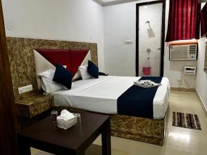 a bedroom with a large bed and a table at wide Hotel in New Delhi