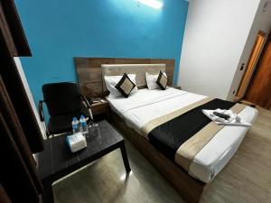 ein Schlafzimmer mit einem Bett, einem Stuhl und einem Tisch in der Unterkunft wide Hotel in Neu-Delhi