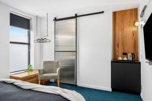 a bedroom with a bed and a chair and a window at The Electric Hotel in Geelong