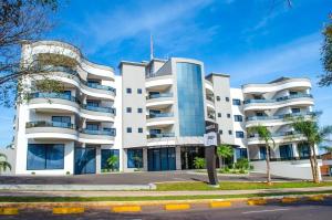 um grande edifício branco com muitas janelas em Seville Park Hotel em Xanxerê