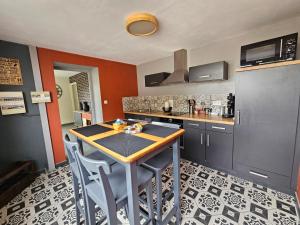 a kitchen with a table and chairs in a room at L'Orée du Bois in Coutiches