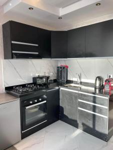 a kitchen with black cabinets and a stove top oven at RIMAL MAHDIA in Kenitra