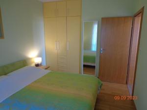 ein Schlafzimmer mit einem Bett, einem Schrank und einer Tür in der Unterkunft Ferienwohnung für 2 Personen   2 Kinder ca 60 m in Ližnjan, Istrien Südküste von Istrien - b53757 in Ližnjan