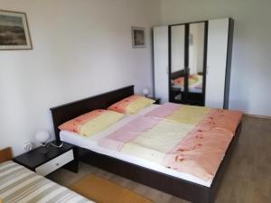 een slaapkamer met een groot bed en een spiegel bij Ferienwohnung für 8 Personen ca 90 qm in Šilo, Kvarner Bucht Krk in Šilo