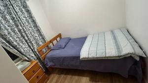 a small bedroom with a bed and a window at Bickley Street in Perth