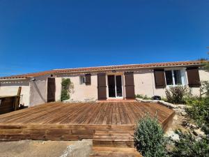 a house with a wooden deck in front of it at Ancienne bergerie de Monteleone vue mer et Citadelle in Bonifacio