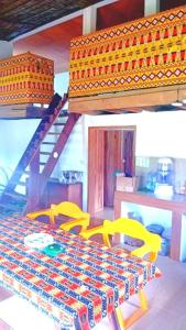 um quarto com um beliche e 2 cadeiras amarelas em Villa 1200m2 de jardin "100m plage" em Kribi