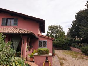 een roze huis met een pad dat er naar toe leidt bij Il Ninfeo " le cocon" appartamento in Zagarolo