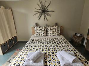 1 dormitorio con 1 cama con reloj en la pared en L'Orée du Bois en Coutiches