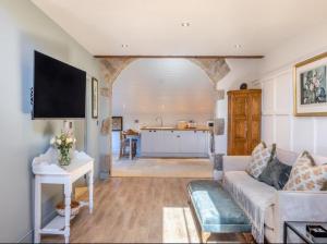 Il comprend un salon avec un canapé et une cuisine. dans l'établissement Lyme Tree Farm Cottages, à Tideswell