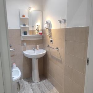 ein Badezimmer mit einem Waschbecken, einem WC und einem Spiegel in der Unterkunft Sole Mio Rooms & Breakfast in Bari
