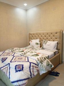 uma cama com uma colcha e almofadas em Kigali Nice Apartment em Kigali