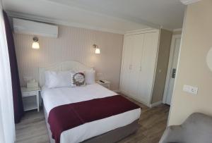 um quarto de hotel com uma cama e uma cadeira em Mr. Bird Hotel em Istambul