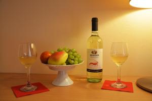 two glasses of wine and a bowl of fruit on a table at Petros Italos in Neos Marmaras