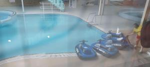 a man is standing next to a swimming pool at WillowWay168, Tranquility Family Home in Camber