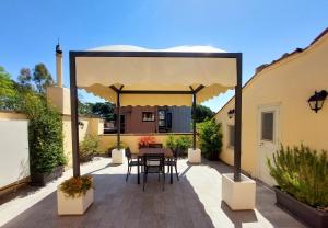 a gazebo with a table and chairs on a patio at Circo Massimo Apartment & Terrace in Rome