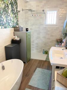 a bathroom with a tub and a sink at Maison proche de la Loire in Saint-Georges-de-Baroille