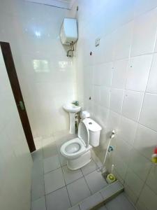 a small bathroom with a toilet and a sink at A private self contained room in a home away from home in Dar es Salaam