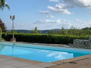 una gran piscina de agua azul en un patio en The Lion House, en Mouzens