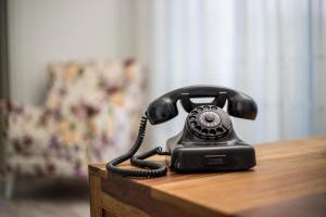 Ammos Apartment - in neu gebautem Designerhaus في فاليراكي: وجود هاتف أسود على طاولة خشبية