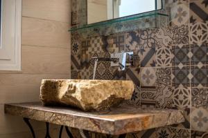 Ammos Apartment - in neu gebautem Designerhaus في فاليراكي: حمام مع حوض صخري ومرآة