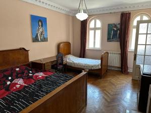 a bedroom with a bed and a table and windows at City center apartment in Constanţa
