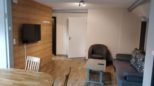 a living room with a couch and a table at Les terrasses des bouleaux Gîtes et Chalets SPA in Ranspach