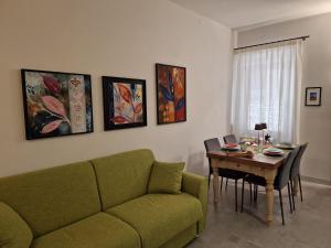 a living room with a green couch and a table at Appartamento Sotto le Torri in San Gimignano