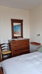 ein Schlafzimmer mit einer Kommode mit einem Spiegel und einem Bett in der Unterkunft MUN Apartment - Major Unforgettable Nights in Fuipiano Valle Imagna
