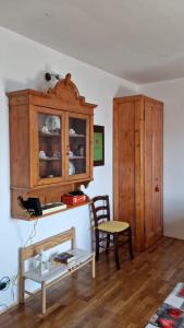 ein Wohnzimmer mit einem Holzschrank und einem Stuhl in der Unterkunft MUN Apartment - Major Unforgettable Nights in Fuipiano Valle Imagna
