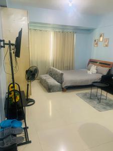 Morgan Suite Hotel في مانيلا: غرفة نوم بسرير وتلفزيون ومرآة