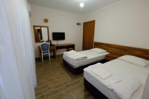 Habitación con 2 camas y escritorio con ordenador. en Venüs Hotel en Antalya