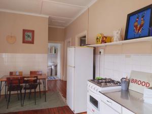 uma cozinha com um frigorífico branco e uma mesa em Riverview Country Inn em Van Reenen
