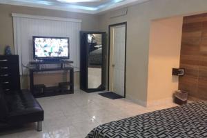 a room with a bed and a television and a mirror at Acogedor departamento en el centro de la ciudad in Reynosa