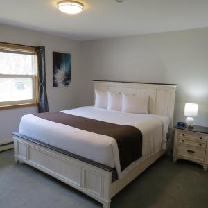 Un dormitorio con una gran cama blanca y una ventana en Dockside Suites en Digby