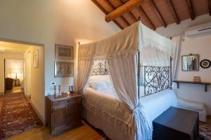 een slaapkamer met een hemelbed in een kamer bij Villa delle Croci in Scandicci